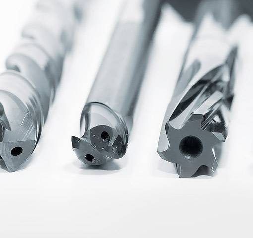 Drei verschiedene Bohrer auf einem weißen Tisch